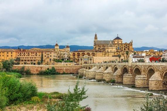 Roman Bridge on Guadalquivir river and Mezquita Cathedral (Great Mosque) at dawn in the city of Cordoba, Andalusia, Spain.